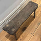 Top view of antique small table made of dark brown wood in a room with white background and hardwood floors