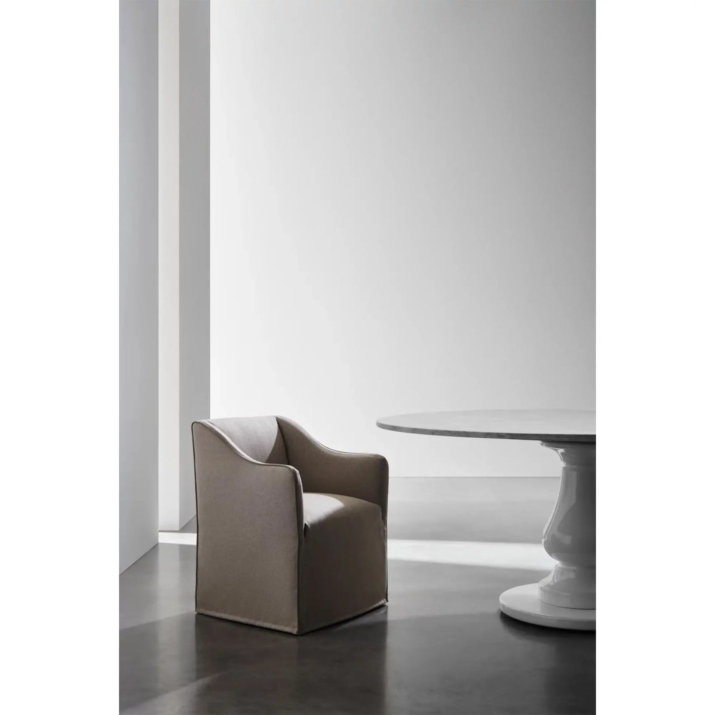 Gervasoni Saia 25 Armchair (partial side view). Pictured with round, marble top table. Chairs USA.